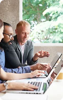 Team collaborating around laptops on an AI project